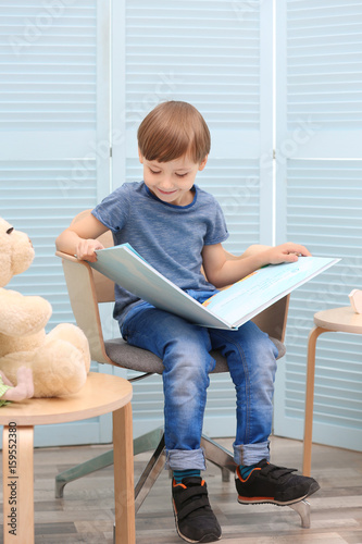 Cute little boy reading boo...