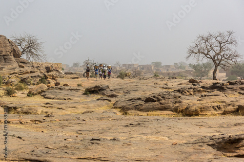 Dogon village women carry water from a well, Dogon Country, Mali