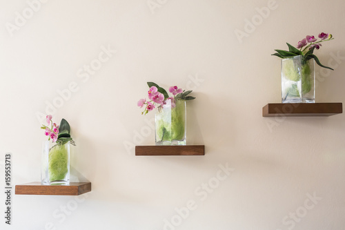 Fototapeta Naklejka Na Ścianę i Meble -  Beautiful orchid in glass vase on shelf.