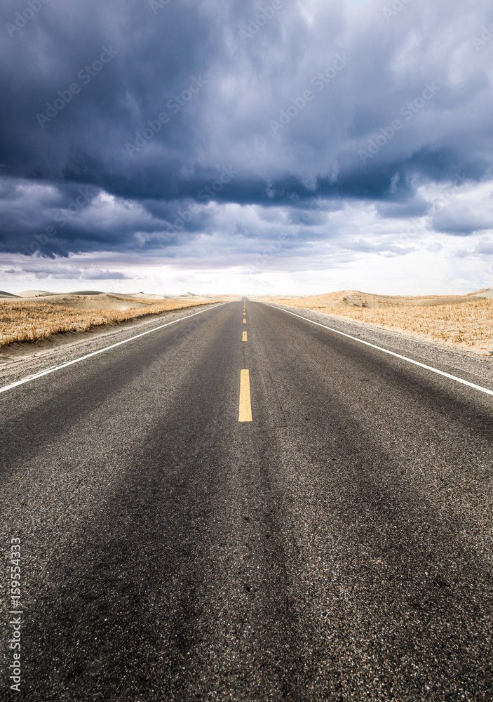 Fototapeta premium Under the clouds, the road to the distance.