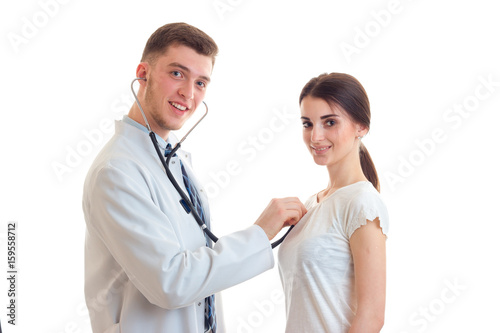 young doctor listens with a stethoscope woman