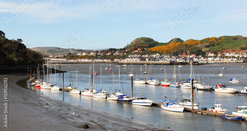 Rows of small motor and fishing boats lined up in Conwy harbour at low tide 