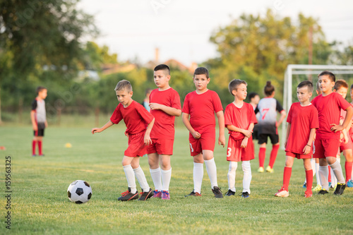 Fototapeta Naklejka Na Ścianę i Meble -  Kids soccer football - children players exercising before match on soccer field