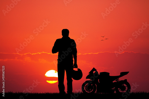 Man with motorbike at sunset