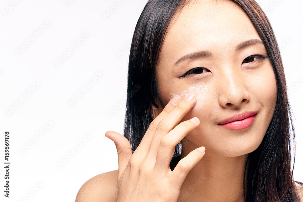 Woman applied cream on face on isolated background Woman applied cream on face on isolated background