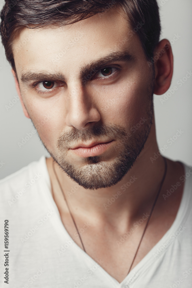 Obraz premium Fashionable male studio portrait. Caucasian white bug with bristles. A large portrait of a guy in a white T-shirt.