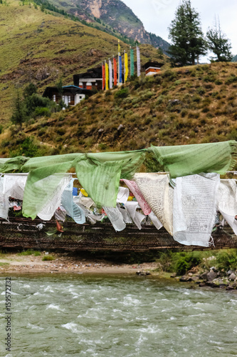 Fototapeta Naklejka Na Ścianę i Meble -  Prayer flags on the iron bridge of Tamchog Lhakhang Monastery, Paro River, Bhutan