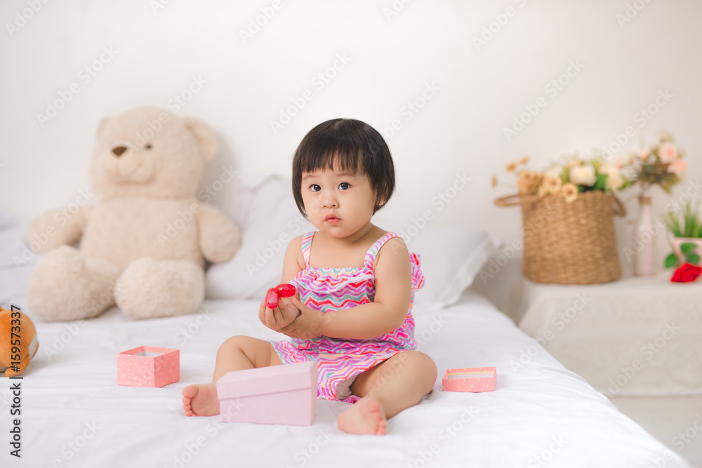 Little cute asian baby girl sitting on bed playing Little cute asian baby girl sitting on bed playing