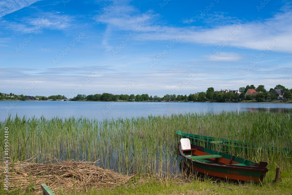 Green boat in the lake on sunny summer day in Lithuania, Trakai. Concept of tranquil country life. Excellent for flyer, post card, advertising, blog, instagram, calendar, notebook, wallpaper