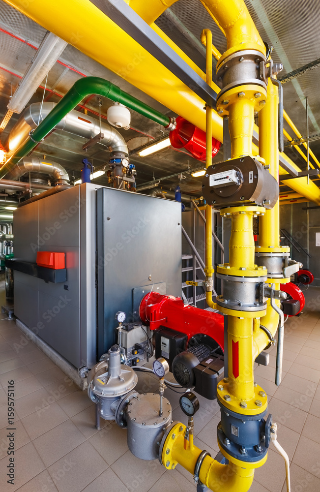 The interior of a modern gas boiler house with boilers, pumps, valves and a multitude of sensors