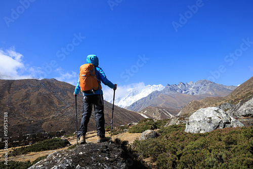Woman backpacker taking photo while trekking at the himalaya mountains
