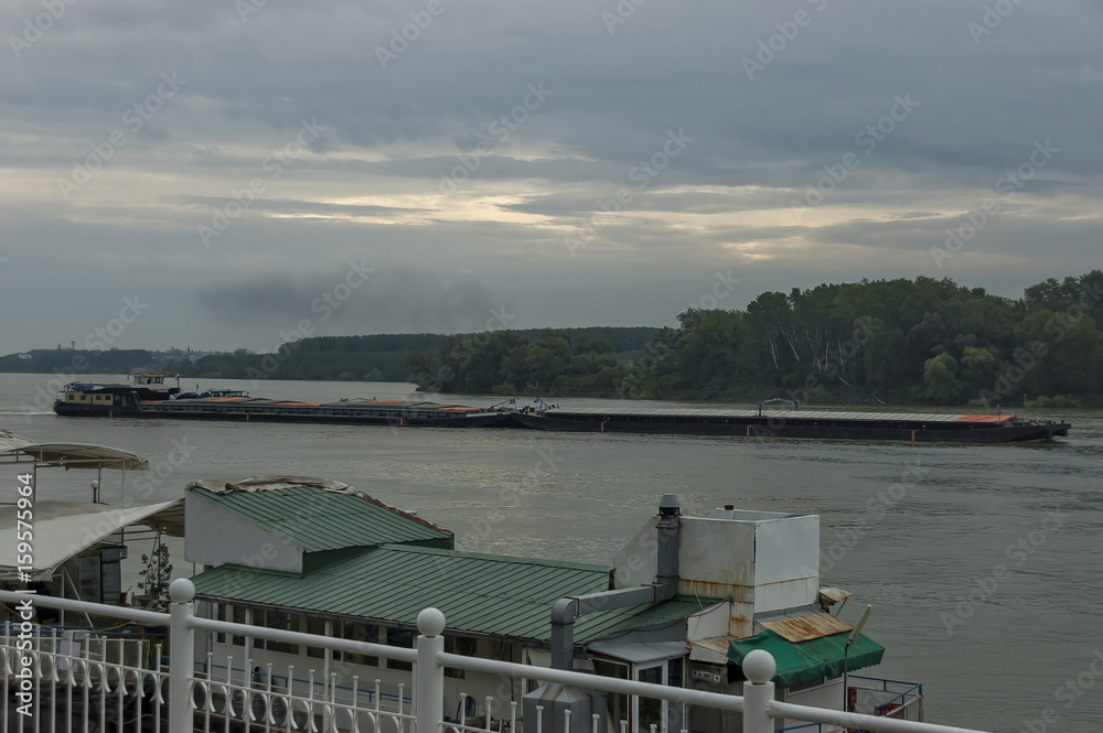 Obraz premium Pass tug-boat along pontoon and boats in the Vidin Danube port, Bulgaria, Europe 