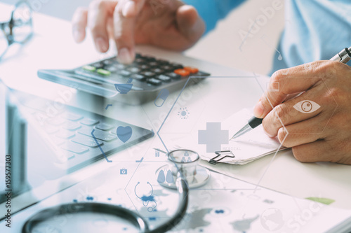 Healthcare costs and fees concept.Hand of smart doctor used a calculator for medical costs in modern hospital photo