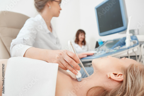 Close up shot of a young woman getting her neck examined by doctor using ultrasound scanner at the modern clinic medicine healthcare professional survey expert doctors concept.
