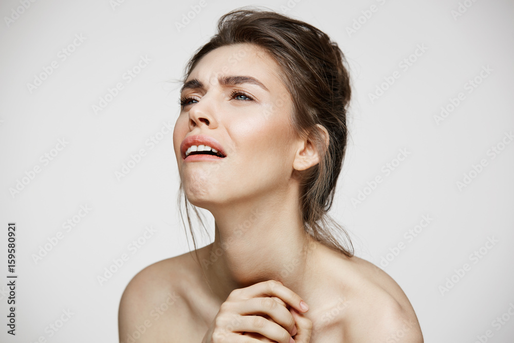 Sad displeased young girl with natural make up over white background. Facial treatment. Sad displeased young girl with natural make up over white background. Facial treatment.