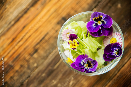 Fresh green salad with herbs and garden flowers. Healthy food concept