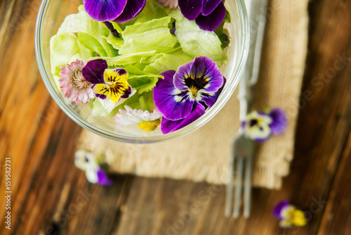 Close up salad leaves garden herbs and edible flowers. Healthy nutrition. Food background