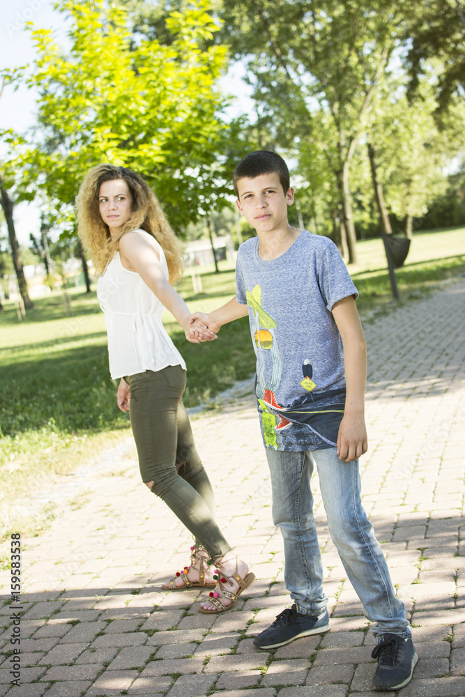 Brother and sister having fun at the park. Big sister and little brother bonding. Smiling and looking at the camera. Brother and sister having fun at the park. Big sister and little brother bonding. Smiling and looking at the camera.