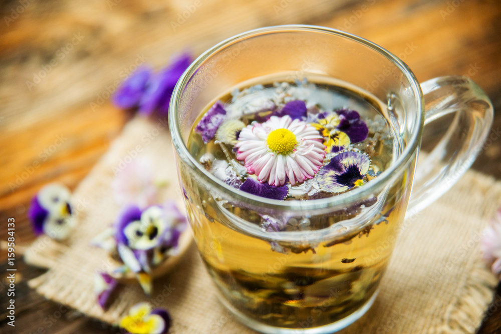Cup of tea with chamomile flowers on rustic wooden background
