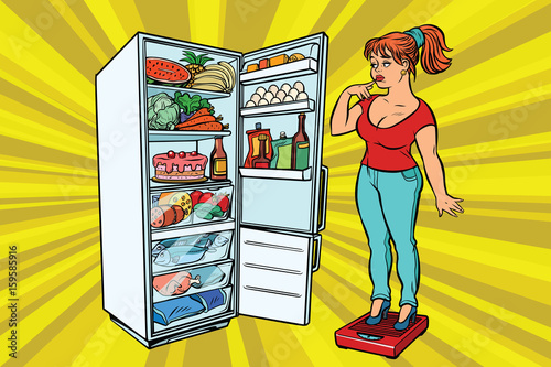 Diet. Young woman on scales, stand next to the refrigerator with