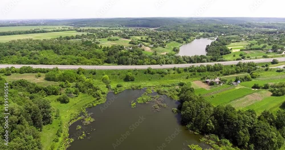 Aerial view of the Kiev-Odessa highway. Flying over cars, trucks, near a green field, a quiet river and a beautiful green forest Aerial view of the Kiev-Odessa highway. Flying over cars, trucks, near a green field, a quiet river and a beautiful green forest