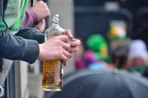 Photography A hand holding a bottle of Irish Whiskey