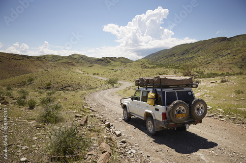 Off road vehicle on dirt path, rear view, Sesfontein, Kaokoland, Namibia photo