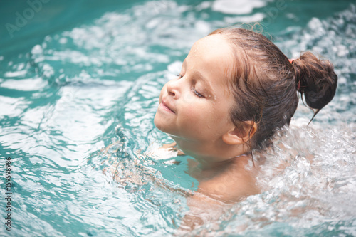 Pretty little girl in swimming pool