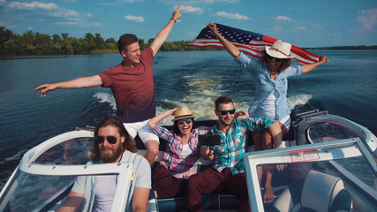 Group of cheerful friends on boat celebrating Independence day and having fun.