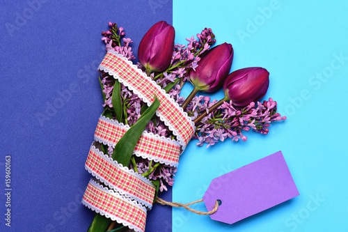 Fototapeta Naklejka Na Ścianę i Meble -  Tulips and lilac gathered in bouquet with ribbon and label