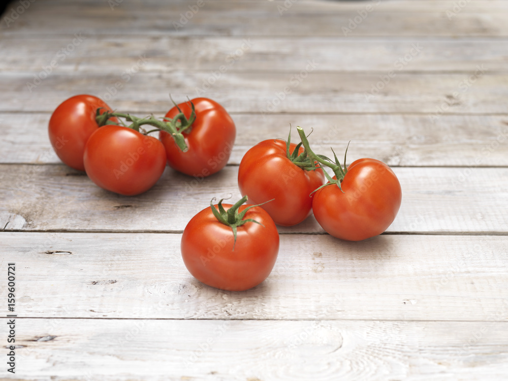 Six red vine tomatoes on wooden table Six red vine tomatoes on wooden table