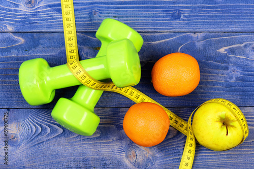 dieting food concept, dumbbells weight with measuring tape, fruit
