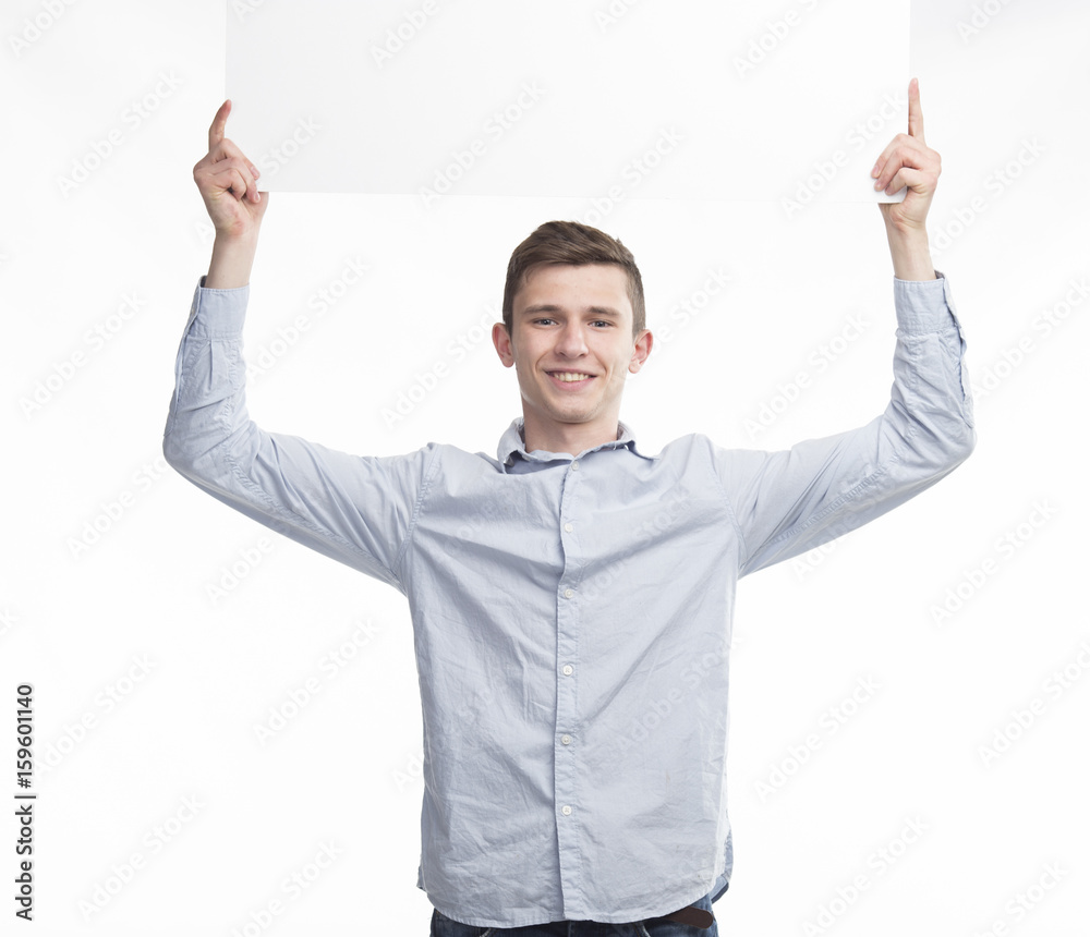 Young happy man showing presentation, pointing on placard over g Young happy man showing presentation, pointing on placard over g