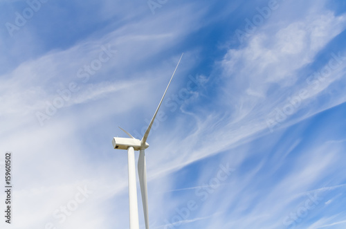 Low angle, close-up view a wind turbine tower again cloud blue sky on a wind farm at Ellensburg, Washington, US. Clean, sustainable, renewable energy concept. Alternative energy source from wind power