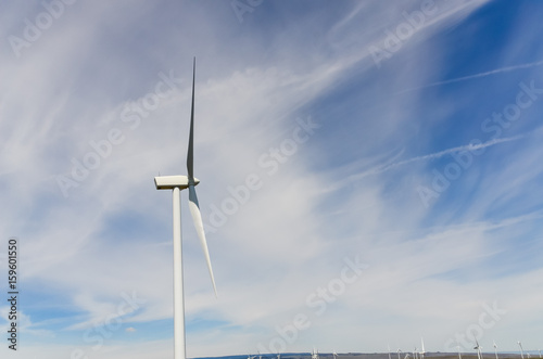 Low angle, close-up view a wind turbine tower again cloud blue sky on a wind farm at Ellensburg, Washington, US. Clean, sustainable, renewable energy concept. Alternative energy source from wind power photo