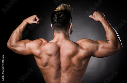фотографія Studio shot of body parts of a topless muscular sportsman over black background