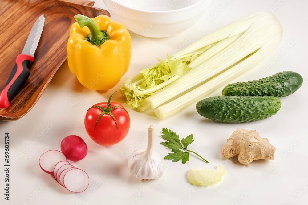 Vegetable salad, vegetarian, pepper, radish, tomato, celery, knife, white background Vegetable salad, vegetarian, pepper, radish, tomato, celery, knife, white background