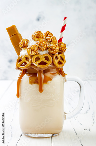 Fotografia Salted caramel indulgent exreme milkshakes with brezel waffles, popcorn and whipped cream