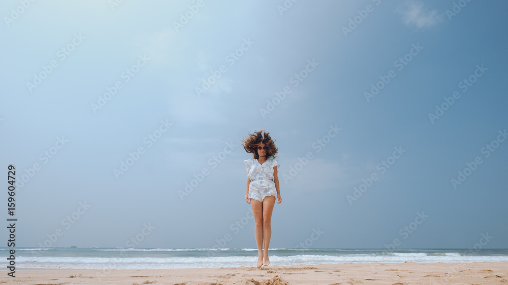 Girl jumping on the beach with flying hair Girl jumping on the beach with flying hair