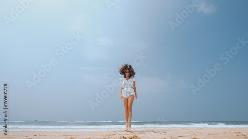 Girl jumping on the beach with flying hair