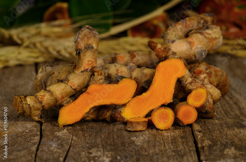pile of fresh turmeric roots on wooden table