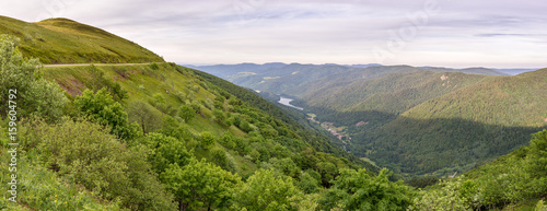 French countryside - Vosges. Panoramic view to a valley in the Vosges with small lake and a village. In the background you can admire the Alps.