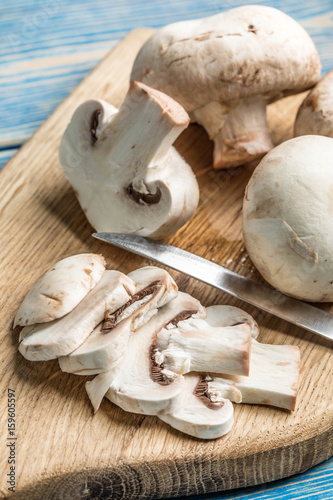 Sliced raw mushrooms on a chopping board.
