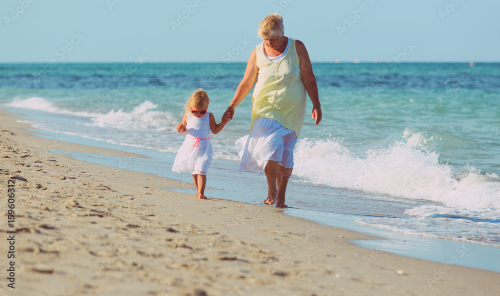 granmother with little granddaughter walk on beach granmother with little granddaughter walk on beach