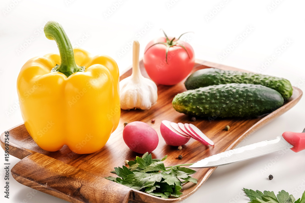 Vegetable salad, vegetarian, pepper, radish, tomato, celery, knife, white background Vegetable salad, vegetarian, pepper, radish, tomato, celery, knife, white background