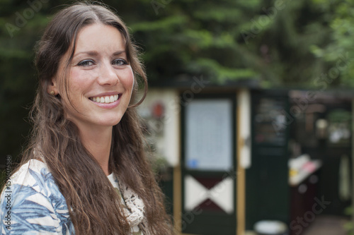 Portrait of young woman in front of chalet photo