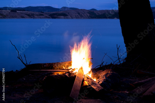 Campfire on the shore of a dam