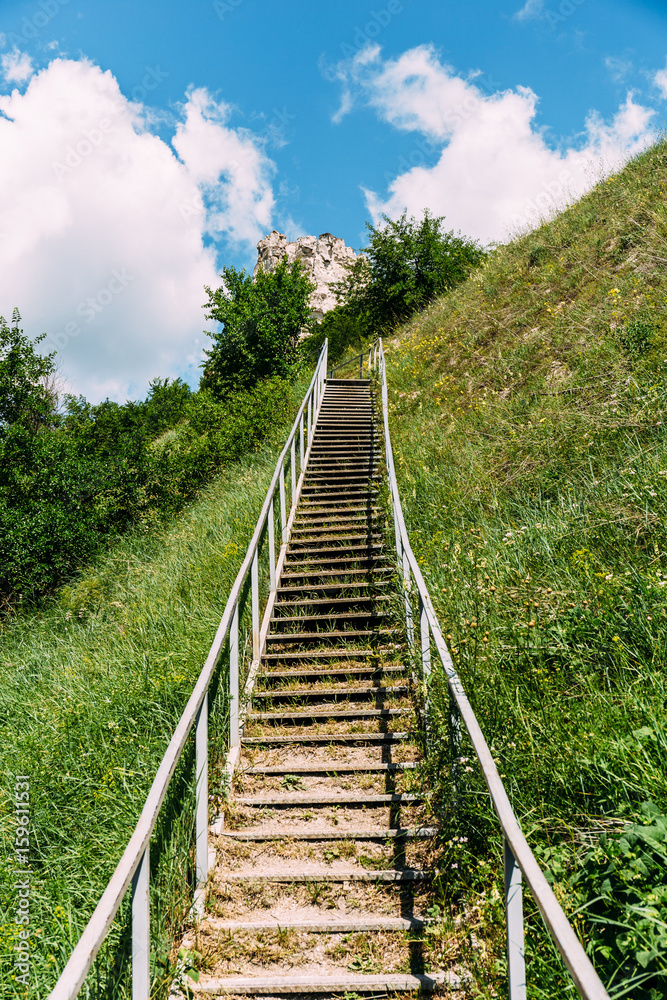 Man-made staircase upstairs to the hill with green grass, travel and tourism concept, vertical Man-made staircase upstairs to the hill with green grass, travel and tourism concept, vertical