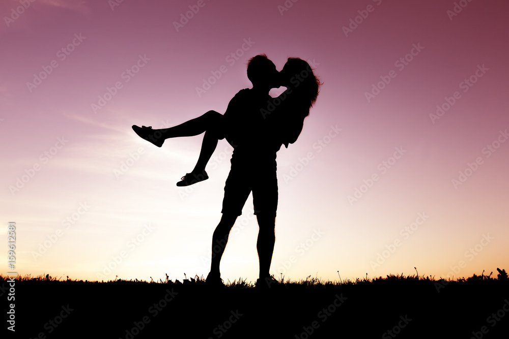 silhouette of romantic lovers with sunset on the back silhouette of romantic lovers with sunset on the back