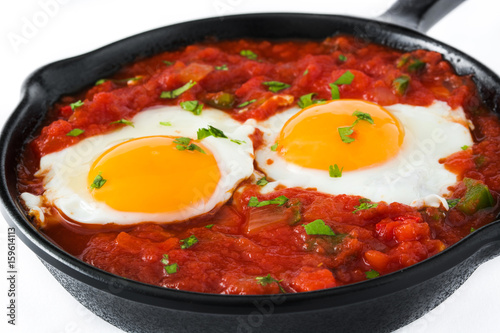 Mexican breakfast: Huevos rancheros in iron frying pan isolated on white background
